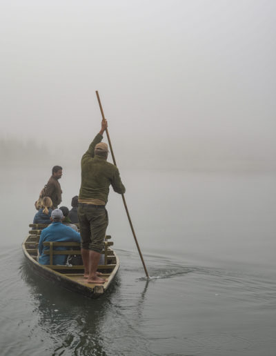 tourists take a trip on a boat into the mist in nepal